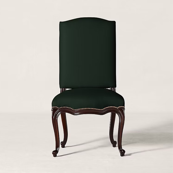 A classic high-back dining chair with a dark forest green upholstered seat and backrest, supported by carved dark brown wooden legs with nailhead trim, set against a plain light beige background.