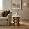 Modern living room with a beige sofa, side table, lamp, and abstract painting.