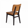 A modern dining chair with a tufted tan leather seat and backrest, supported by a dark wood frame, shown from a three-quarter angle on a white background.