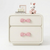 White dresser with pink bow accents on a white background