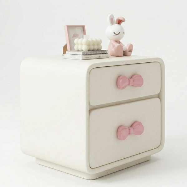 White nightstand with pink bow handles on a white background