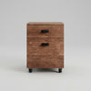 Wooden file cabinet with two drawers on wheels in a room with a green wall.