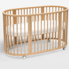 Wooden crib with white mattress on a light background