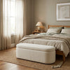 Neatly arranged bedroom with a bed, ottoman, and decor elements.