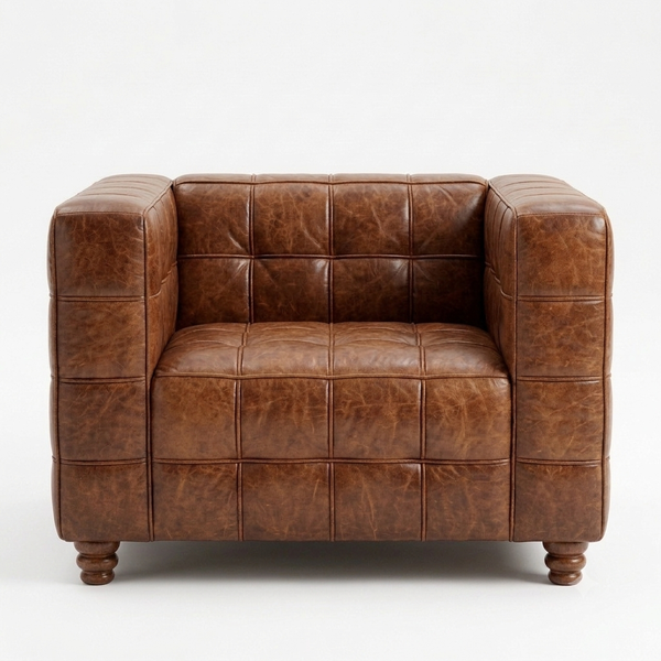 A brown tufted leather armchair with a distressed finish and turned wooden legs, photographed against a plain white background.