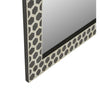 Decorative mirror with a geometric patterned frame on a white background