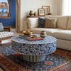 Living room with a round blue and white patterned coffee table, beige sofa, and decorative pillows.