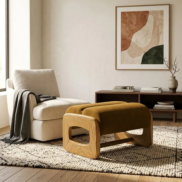Modern living room with a beige sofa, wooden ottoman, and abstract art on the wall.