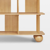 Wooden shelf with wheels on a light gray background