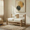 Wooden sofa with white cushion in a room with abstract art on the wall.