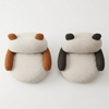 Two dog-shaped cushions with brown and black accents on a white background