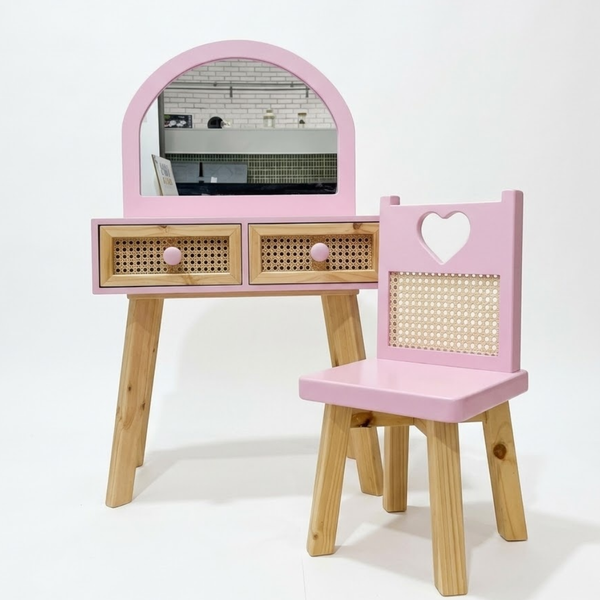 Pink vanity table with mirror and chair on a white background
