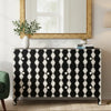 Black and white patterned sideboard in a living room setting with a mirror and plant.