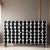 Black and white patterned dresser against a gray wall