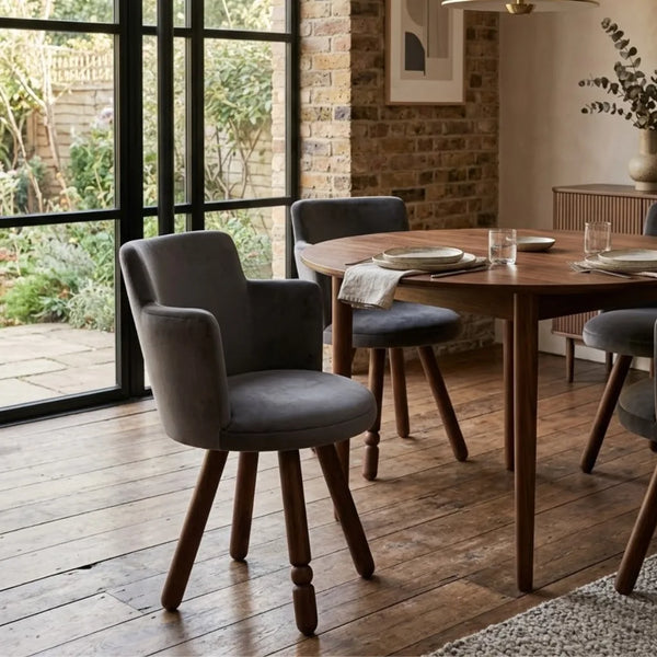Dining room with wooden table and gray chairs on a wooden floor.
