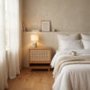 Wooden side table with wicker door against a tiled wall
