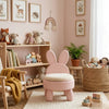 Children's room with pink bunny chair, bookshelf, and toys.