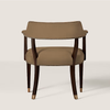 A modern accent chair with a curved taupe upholstered backrest and seat, dark brown wooden legs, and brass nailhead trim and foot caps, shown against a light beige background.