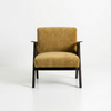 A modern armchair with mustard yellow velvet upholstery and a dark wood frame, photographed against a seamless white studio background.
