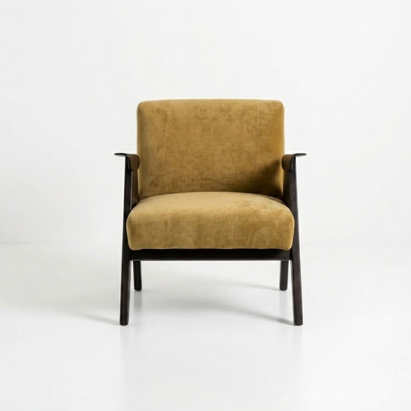 A modern armchair with mustard yellow velvet upholstery and a dark wood frame, photographed against a seamless white studio background.