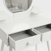 White vanity table with a round mirror and open drawer on a white background