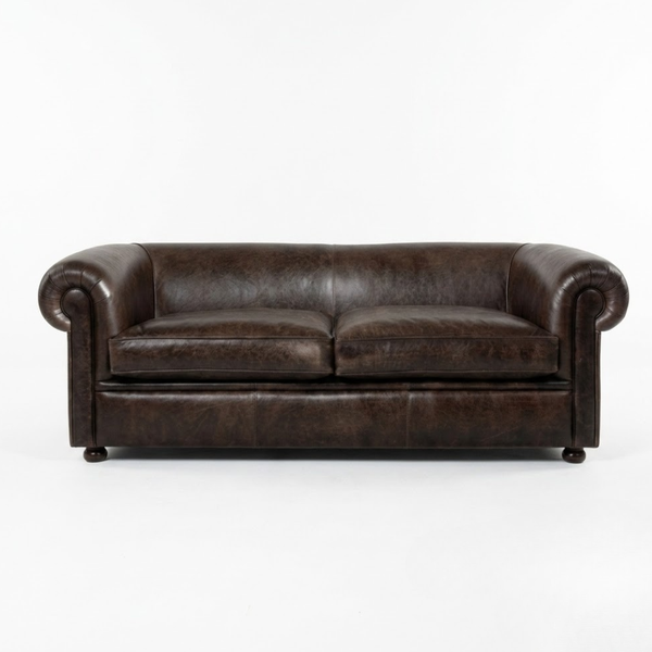 A dark brown leather loveseat sofa with rolled arms and two seat cushions, photographed against a plain white studio background.