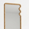 Rectangular mirror with a wavy wooden frame on a white background