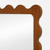 Wooden mirror frame with wavy design on a white background