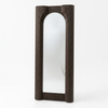 A tall, narrow wall mirror with a dark brown fluted frame, featuring an arched top and bottom, set against a plain white background.