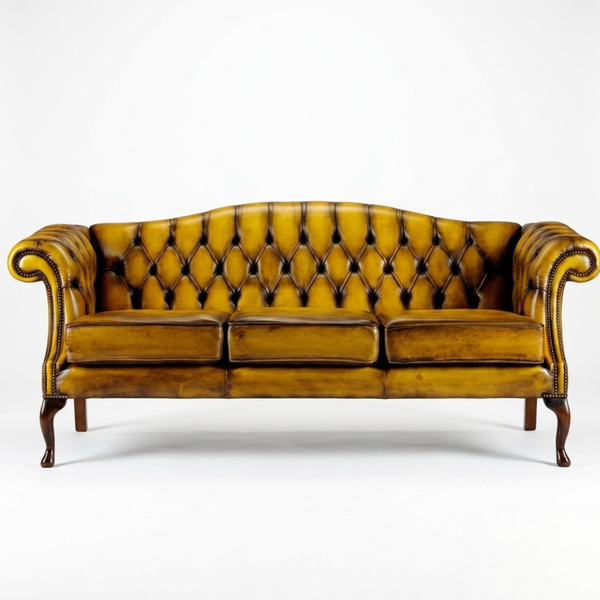 A classic three-seater tufted leather sofa in a rich mustard yellow color, featuring dark brown wooden legs and trim, photographed against a seamless white background.