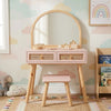 Children's vanity table with mirror and stool against a colorful wall with rainbow and cloud patterns.