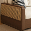 Brown wicker headboard against a white sofa with a black and white patterned pillow.