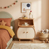 Children's bedroom with wooden nightstand, bed, and toys.