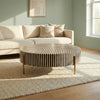 Beige sectional sofa with striped coffee table in a bright living room