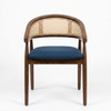 A mid-century modern accent chair with a dark brown wooden frame, a woven cane backrest, and a blue upholstered seat cushion, shown against a plain white background.