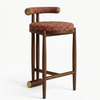Wooden bar stool with a red cushioned seat and backrest on a white background