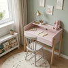 Children's desk with chair in a room with light green walls, a window, and decorative elements.