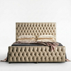 A tufted upholstered bed frame in a warm beige/taupe leather, shown with matching pillows and a draped throw blanket against a clean white studio background.