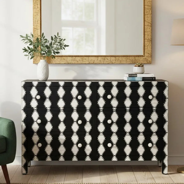 Black and white patterned sideboard in a living room setting with a mirror and plant.