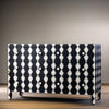 Black and white patterned dresser against a neutral wall