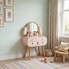 Children's room with a cute wooden vanity table and chair, colorful rug, and teddy bear decorations.