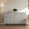 Decorative chest of drawers with geometric pattern in a room setting.