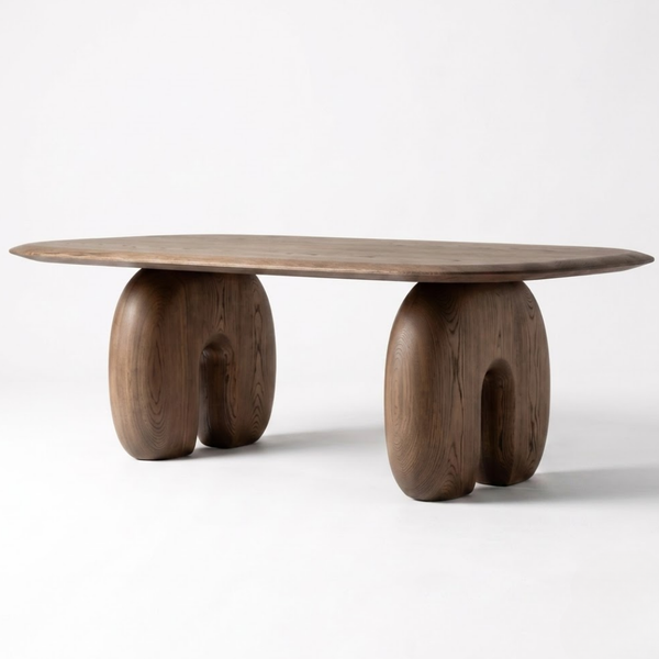 A modern wooden dining table with a rounded rectangular top and two sculptural, curved legs, shown on a clean white studio background.