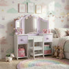 Children's bedroom with a vanity table, colorful rug, and decorative wall art.
