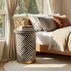 Patterned side table in a bedroom with a bed and curtains